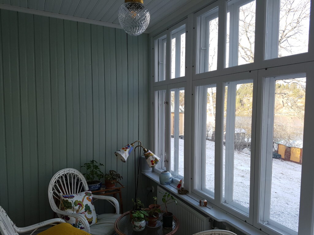 Glasveranda där 120 år gamla enkelglasfönster har kompletterats med nya innanfönster för att ge åretruntkomfort och spara energi utan att påverka husets karaktär