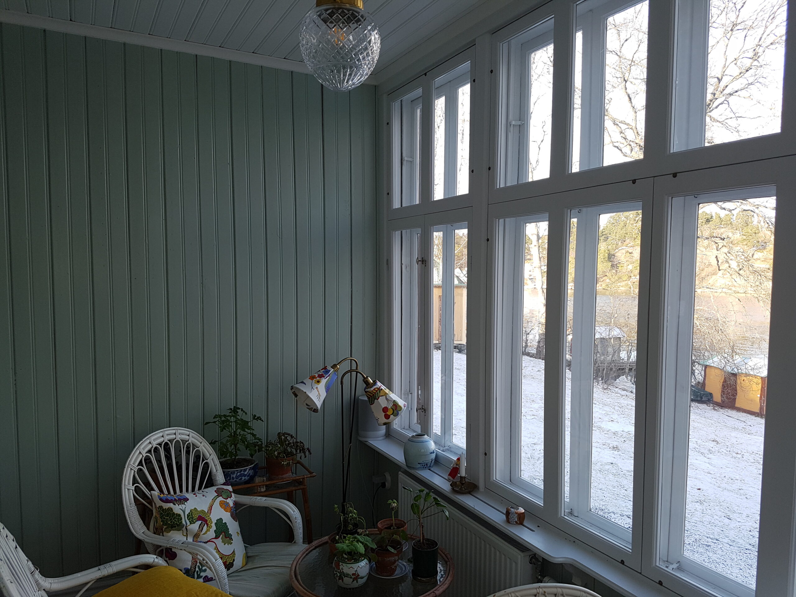 Glasveranda där 120 år gamla enkelglasfönster har kompletterats med nya innanfönster för att ge åretruntkomfort och spara energi utan att påverka husets karaktär
