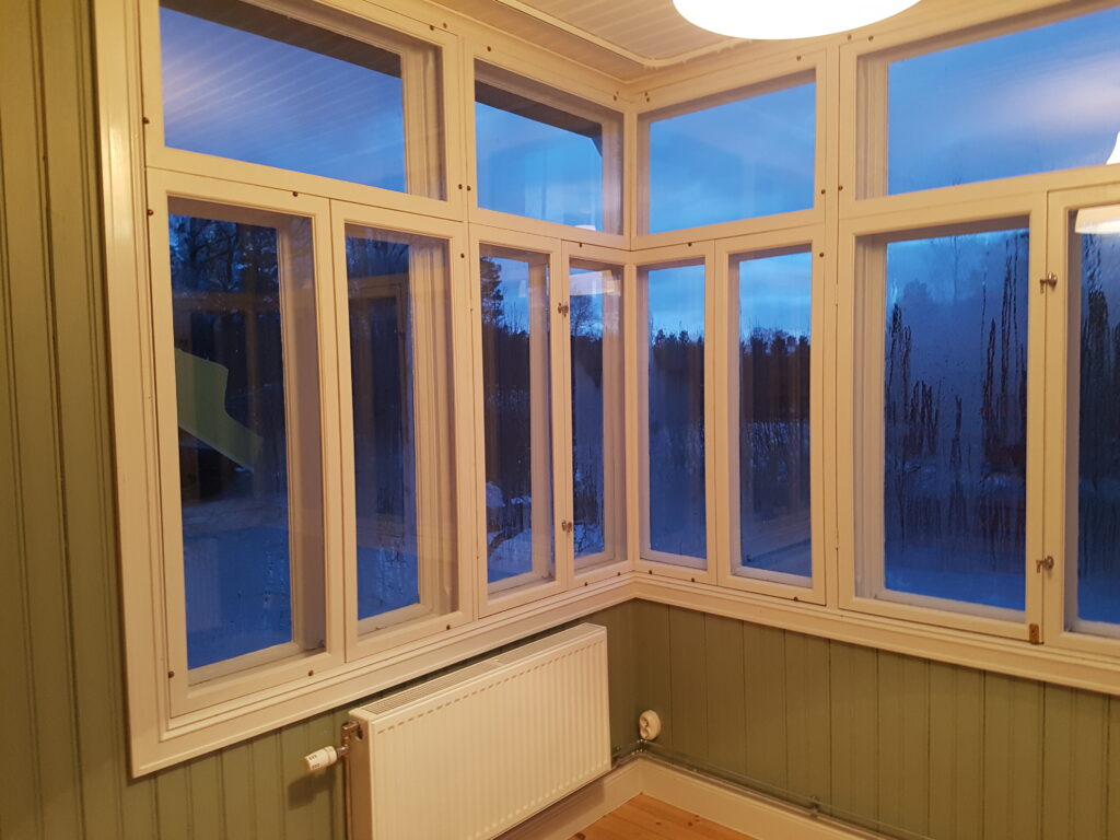 En äldre glasveranda med enkelglas där karmarna har byggts på för att möjliggöra nya innanfönster. Gör det möjligt att ha glasverandan uppvärmd året om och ger ett behagligt inomhusklimat utan stora energiförluster.