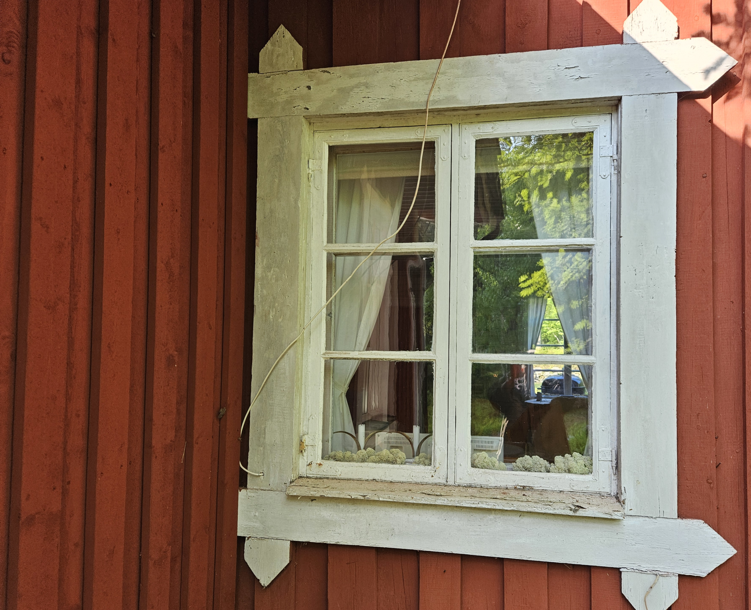 Brädvägg med faluröd lockytterpanel.